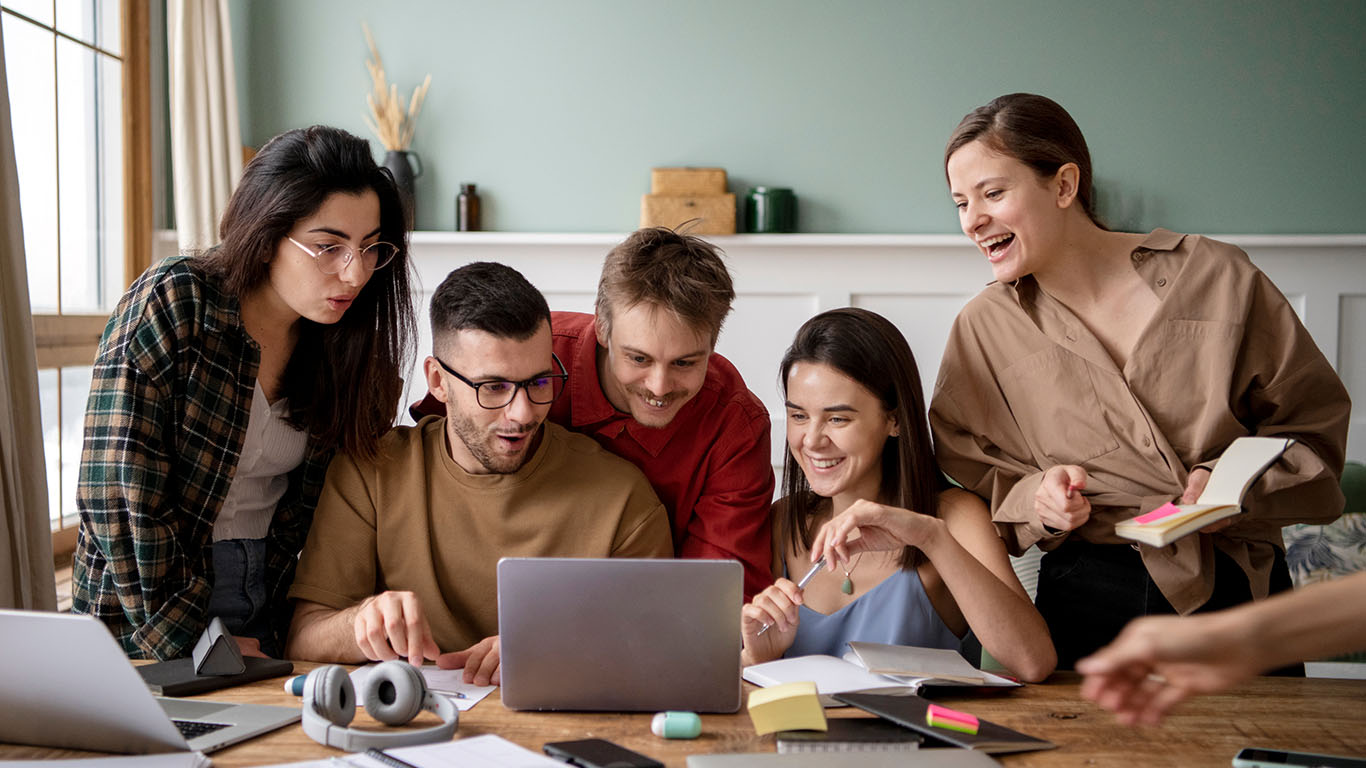 Team members collaborating around a laptop during a planning session