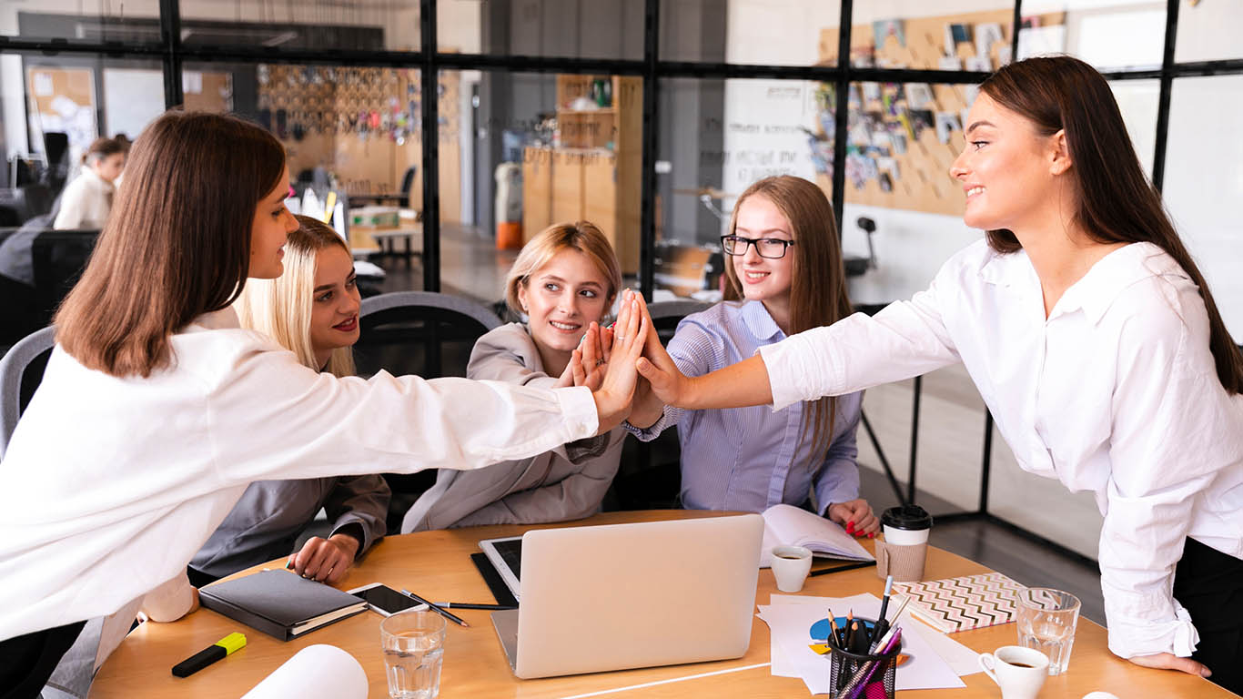 A team gathered in a meeting room discussing workflow improvements